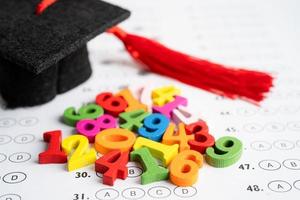 sombrero de brecha de graduación y lápiz en el fondo de la hoja de respuestas, concepto de enseñanza de aprendizaje de prueba de estudio de educación. foto