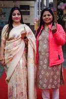New Delhi, India - December 04 2022 - Unidentified people showing their ink-marked fingers after casting votes in front of polling booth of east Delhi area for MCD local body Elections 2022 photo