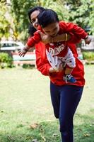 Loving mom carrying of her baby at society park. Bright portrait of happy mum holding child in her hands. Mother hugging her little 9 months old son. photo