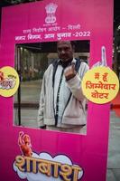 New Delhi, India - December 04 2022 - Unidentified people showing their ink-marked fingers after casting votes in front of polling booth of east Delhi area for MCD local body Elections 2022 photo