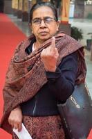 New Delhi, India - December 04 2022 - Unidentified people showing their ink-marked fingers after casting votes in front of polling booth of east Delhi area for MCD local body Elections 2022 photo