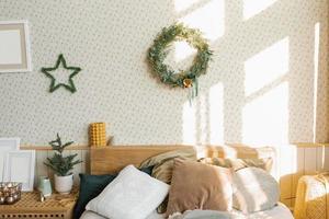 A bed with pillows and Christmas decorations in the bedroom in a Scandinavian style. photo