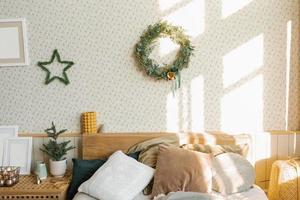 A bed with pillows and Christmas decorations in the bedroom in a Scandinavian style. photo