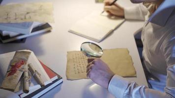 el joven hombre examina el histórico medieval comunicativo carta. inscripción científico. video