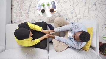 Muslim african married couple holding hands and daydreaming looking at sky at home. Dreamy muslim married couple holding hands in their home and dreaming of good days. video