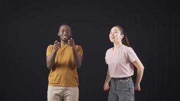 African American man and Asian young woman dancing and happy. Asian young woman and African young man dancing and having fun together. Interracial friends. video