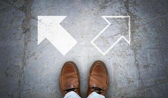 Brown Leather Shoes and Two Chalky Arrows on Asphalt - Choice Concept photo