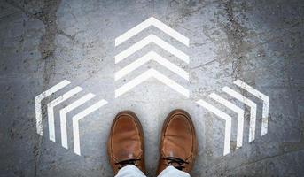 Brown Leather Shoes and Three Chalky Arrows on Asphalt - Decision Concept photo