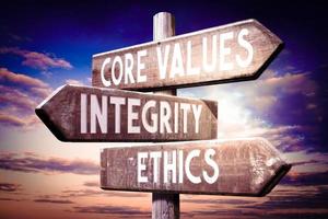 Core Values, integrity, Ethics - Wooden Signpost with Three Arrows, Sunset Sky in Background photo