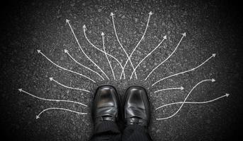 Black Business Shoes and Many Winding Chalky Arrows on Asphalt - Decision Concept photo