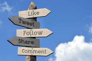 Like, Tweet, Follow, Share, Comment - Wooden Signpost with Five Arrows, Sky with Clouds photo