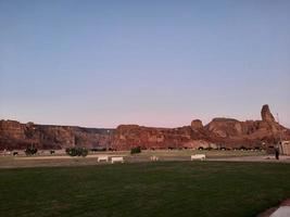 A beautiful daytime view of a winter park in Al Ula, Saudi Arabia. The park is surrounded by ancient hills. photo