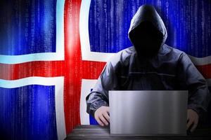 Anonymous Hooded Hacker and Flag Of Iceland, Binary Code - Cyber Attack Concept photo