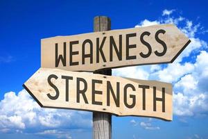 Weakness, Strength - Wooden Signpost with Two Arrows, Sky with Clouds in Background photo