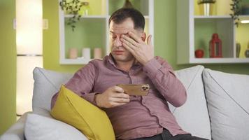 homme avec endolori poignet de dépenses aussi beaucoup temps sur téléphone intelligent. La technologie dépendance. homme main fait mal de en jouant Jeux, en train de regarder films, dépenses temps sur le téléphone et le homme bloque en haut. video