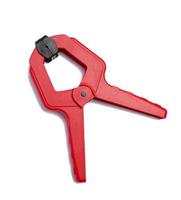 Large  red plastic clamp on a white isolated background photo