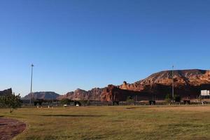 A beautiful daytime view of a winter park in Al Ula, Saudi Arabia. The park is surrounded by ancient hills. photo