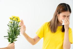 polen alergias, asiático joven mujer estornudos en un pañuelo o soplo en un limpiar, alérgico a salvaje primavera flores o flores durante primavera. alérgico reacción, respiratorio sistema problemas foto