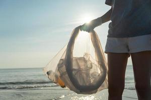 Save water. Volunteer pick up trash garbage at the beach and plastic bottles are difficult decompose prevent harm aquatic life. Earth, Environment, Greening planet, reduce global warming, Save world photo