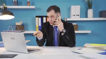 homem de negocios trabalhando dentro escritório fazer telefone ligar sobre negócios. homem de negocios fazer telefone ligar sobre o negócio e analisando às a mesmo tempo. video