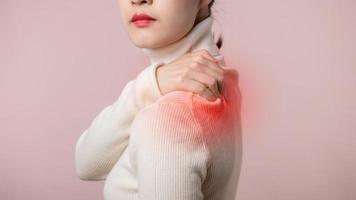 Asian young woman hold her hand on pain neck and injury ache shoulder stress problem muscle. Office syndrome disease, Healthcare world health day concept. photo