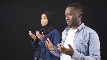 afrikanisch Muslim Jugend beten. Muslim Jugend beten und Anbetung Allah. Muslim jung Frau im Hijab und ihr Freund beten zusammen.