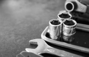 Hand tools consisting of wrenches, pliers, socket wrenches, laid out on old steel plate background. photo