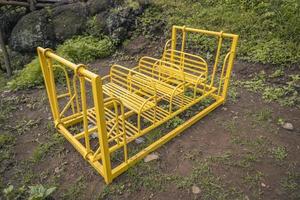 el amarillo hierro balanceo en el niños patios de recreo el foto es adecuado a utilizar para jugar suelo fondo, niños jugar y divertido al aire libre contenido.