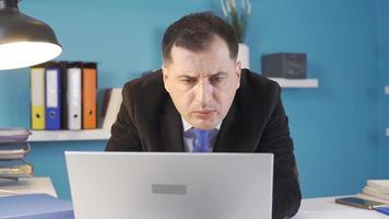 empresario mirando a computadora en oficina. el empresario es seriamente trabajando desde el computadora. video