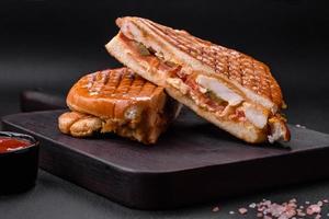 Delicious crispy sandwich with chicken breast, tomatoes, ketchup and spices photo