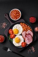 delicioso nutritivo Inglés desayuno con frito huevos y Tomates foto