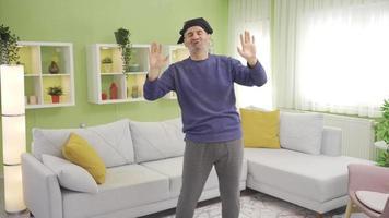 Cheerful and fun mature man is dancing at home, being happy, keeping his life energy high. Funny old man dancing alone at home, having fun, smiling. video