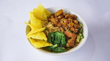 Mie Ayam or Bami ayam, noodles with chicken and served with meatballs and deep-fried wonton pangsit Indonesian food, photo