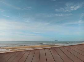 empty top of old wooded table and view of tropical beach and sky background. For present your products. photo