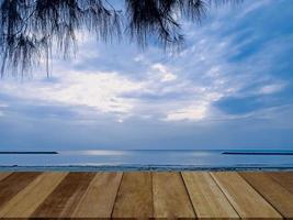 empty top of old wooded table and view of tropical beach and sky background. For present your products. photo