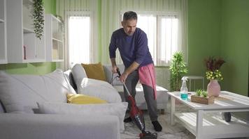 un maduro hombre limpia su casa, aplicando higiene reglas para un limpiar casa. maduro hombre limpieza mesa con limpieza rociar contento y satisfecho con limpieza su casa. video