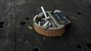 ashtray and cigarette butts on wooden table in outdoor bandung seafood restaurant photo