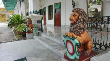 The statue of a lion in the Yogyakarta Palace symbolizes the royal power of the palace in Java photo