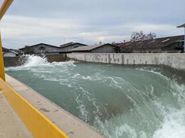 Texture and surface of seawater fall on the power plant with foaming on the outfall. The photo is suitable to use for industry background, environment poster and nature content.