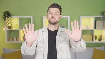 Young man making no, stop, no gestures towards the camera with his hands and gestures. Young man jes makes negative gestures towards the camera, using his gestures and hands. video