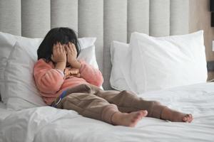 un trastornado niño niña cubrir su cara con mano foto