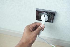 white color power cord cable plugged into wall photo