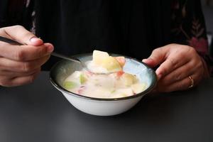 fresh fruits mixed with yogurt in a bowl on table photo
