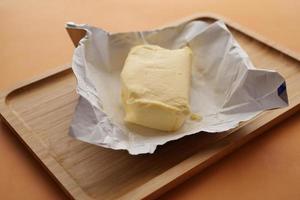 slice of a butter on a paper on table photo