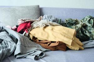 Messy clothes on sofa at home photo