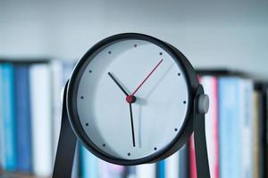 simple modern clock on a book shelf . photo