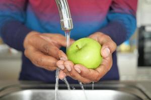 Fresco manzana Lavado con mano. foto