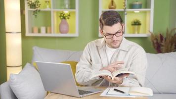 le diligent étudiant regards à le caméra tandis que Faire recherche et spectacles cette il est contenu. video