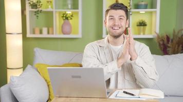 das Mann Umgang mit das Laptop plötzlich sieht aus beim das Kamera und beginnt klatschen mit ein lächeln. video