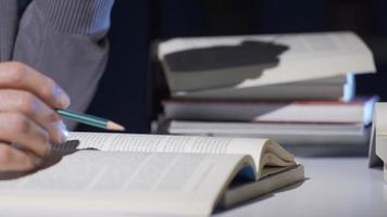 Close-up Researcher, historian, mature old man doing historical research reading a book. A historian who reads, translates and writes scientific books. video